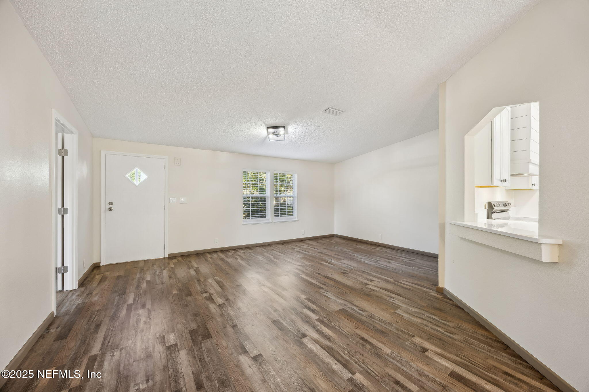 6034 Leona Padgett Road Jacksonville, FL 32234 - Photo 10 of 37 an empty room with wooden floor and windows