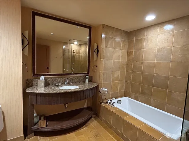 a bathroom with a tub sink and mirror