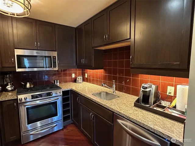 a kitchen with granite countertop a stove and a microwave