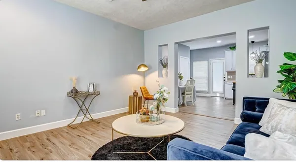 a living room with furniture a dining table and a chandelier