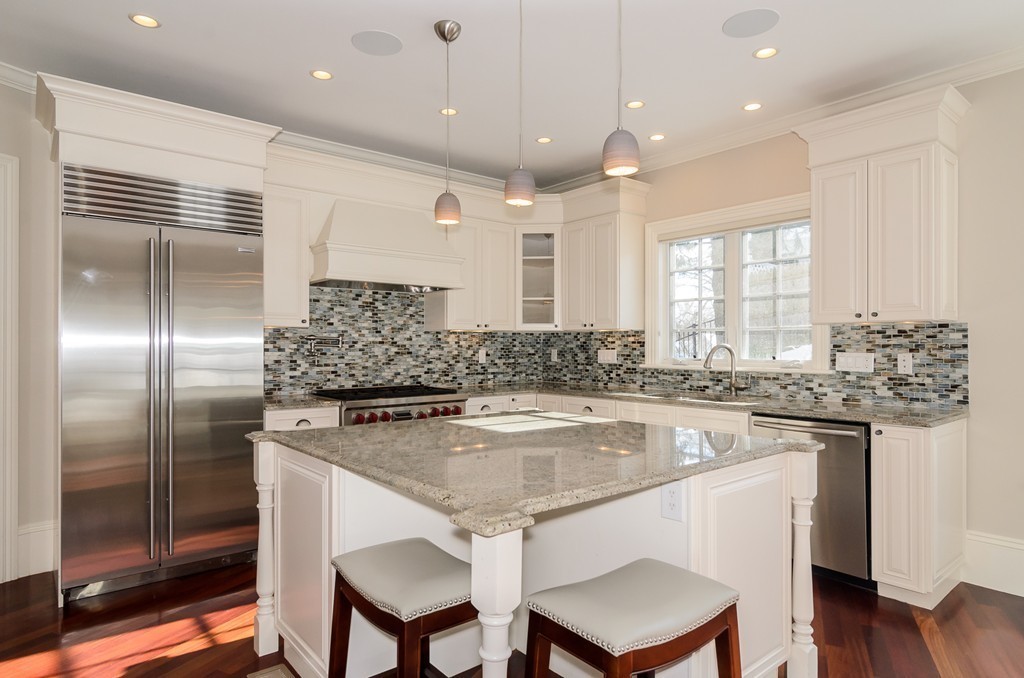 24 Audubon Road Wellesley, MA 02481 - Photo 9 of 19 a kitchen with stainless steel appliances granite countertop a sink and a refrigerator