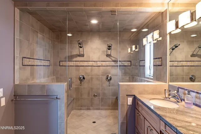 a bathroom with a granite countertop shower sink and cabinets
