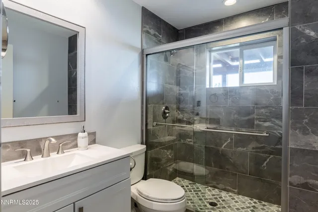 a bathroom with a sink toilet a mirror and shower