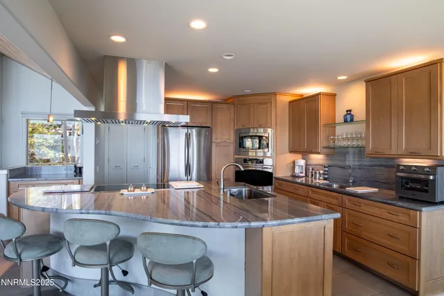 a kitchen with stainless steel appliances kitchen island granite countertop a sink and cabinets
