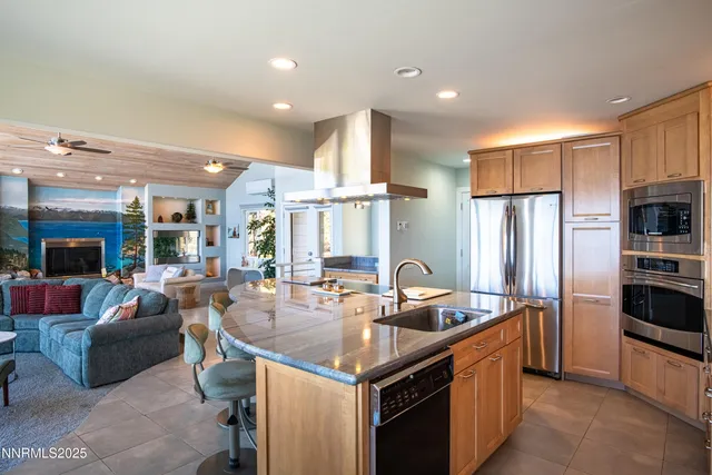 a kitchen with stainless steel appliances granite countertop a sink a stove and a refrigerator