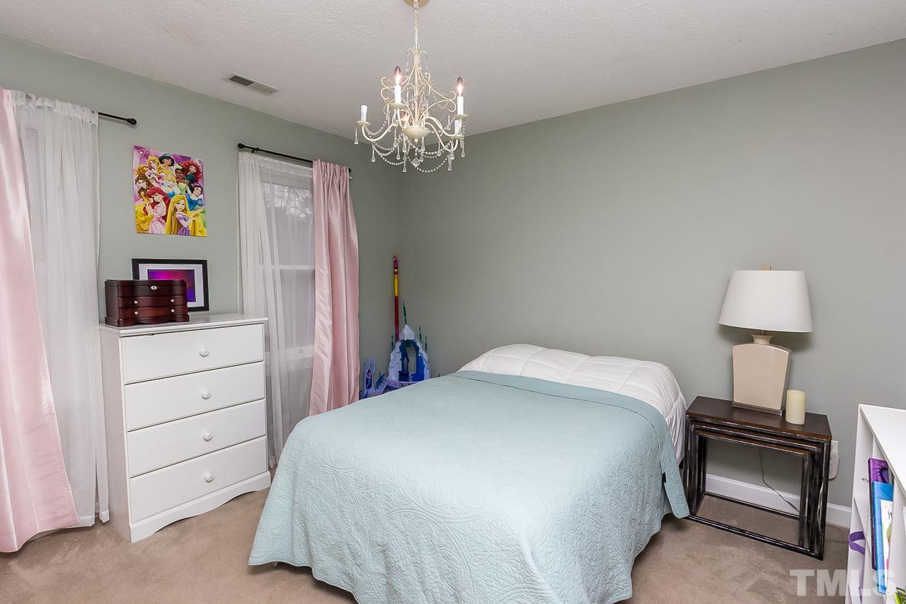 11916 Radner Way Raleigh, NC 27613 - Photo 14 of 29 a bedroom with a bed and a chandelier