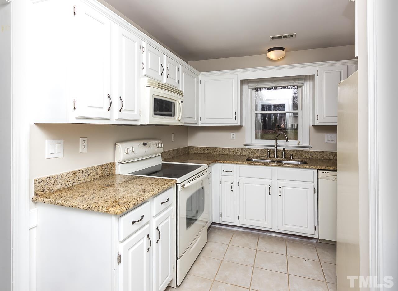 11916 Radner Way Raleigh, NC 27613 - Photo 6 of 29 a kitchen with granite countertop white cabinets and a sink