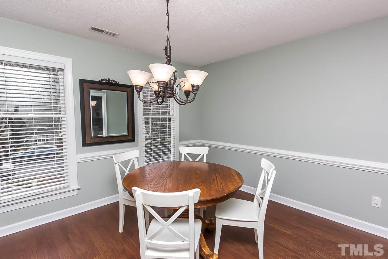 11916 Radner Way Raleigh, NC 27613 - Photo 9 of 29 a dining room with furniture wooden floor and a chandelier