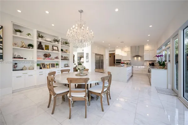 a dining room with stainless steel appliances furniture large window and chairs