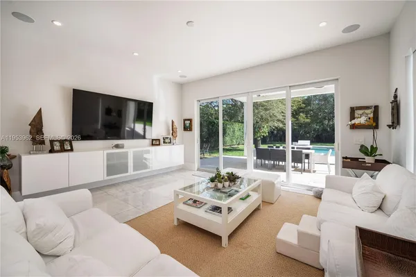 a living room with furniture and a dining table with kitchen view