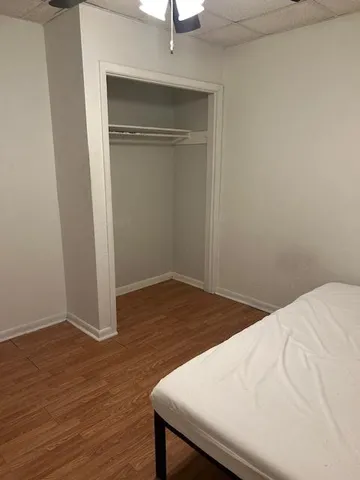 a room with a bed and wooden floor