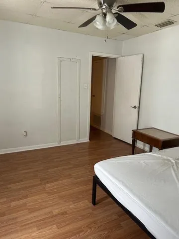 a bedroom with a bed and a ceiling fan