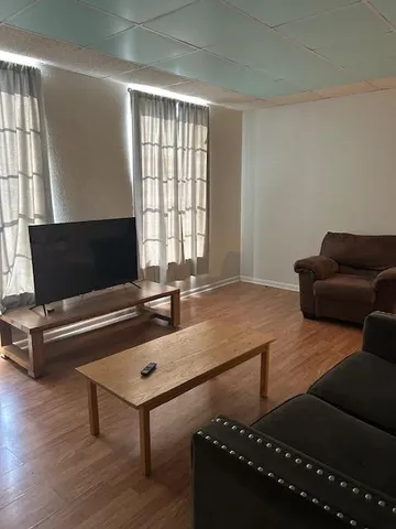 a living room with furniture pool table and a window