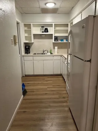 a kitchen with a refrigerator and white cabinets
