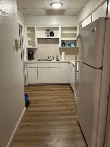 a kitchen with a refrigerator and white cabinets