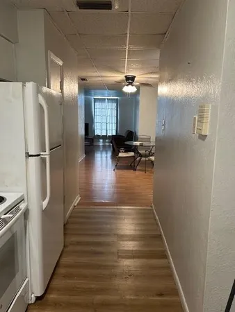 a view of a hallway with wooden floor and chairs