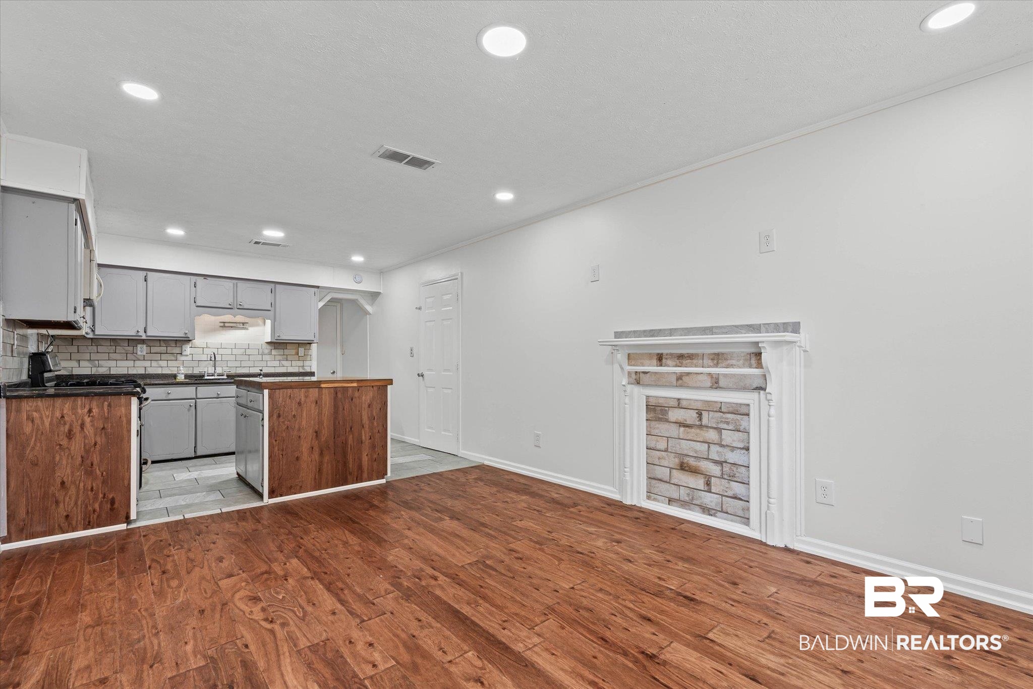 1211 Alba Street Mobile, AL 36605 - Photo 6 of 22 Kitchen with recessed lighting, dark countertops, decorative backsplash, light wood finished floors, and gray cabinetry