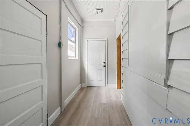 a view of a hallway with wooden floor and staircase