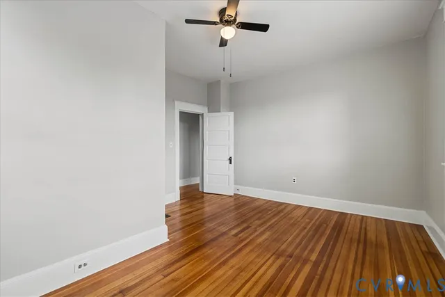 a view of a room with wooden floor and fan