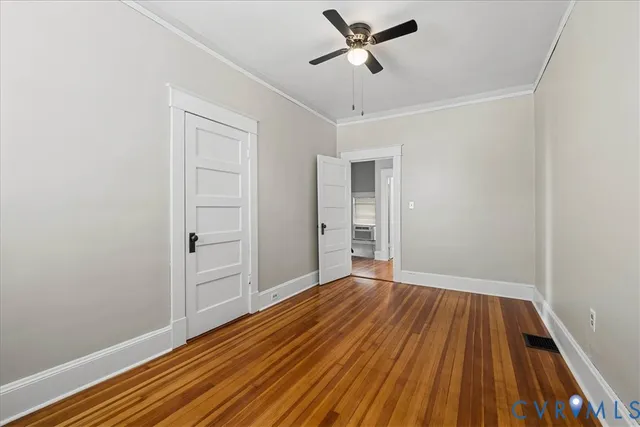 a view of empty room with wooden floor