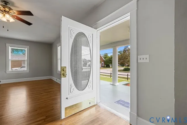 a view of a hallway with wooden floor and a bathroom