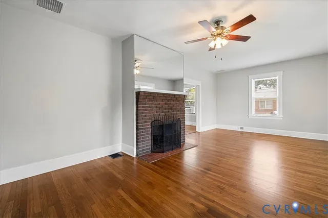 an empty room with windows and fireplace