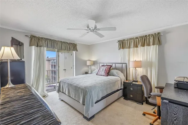 a bedroom with a bed a large window and a chandelier