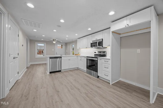 a kitchen with white cabinets and stainless steel appliances