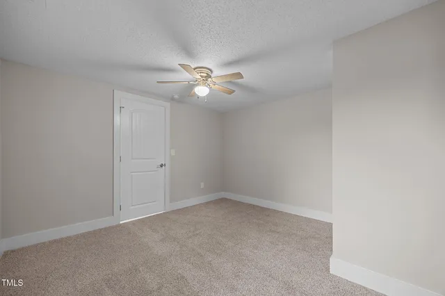 an empty room with a ceiling fan and a window