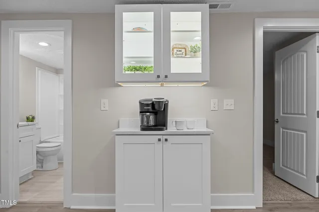a bathroom with a granite countertop toilet a sink and a window