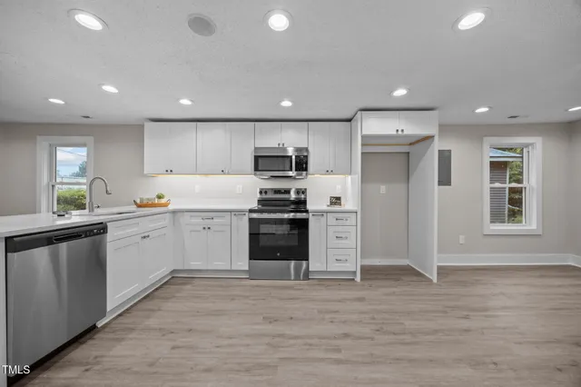 a kitchen with a sink stainless steel appliances and cabinets