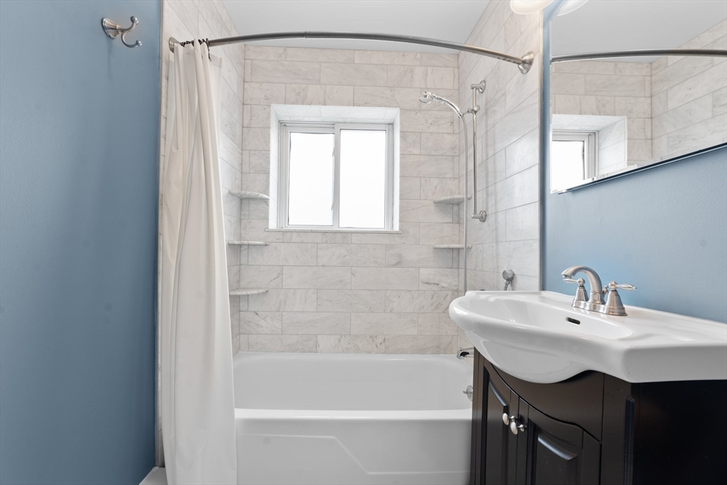 26 Westgate Road, Unit 264 Chestnut Hill, MA 02467 - Photo 16 of 30 a bathroom with a sink a mirror and a bathtub