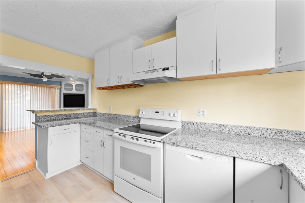 26 Westgate Road, Unit 264 Chestnut Hill, MA 02467 - Photo 9 of 30 a kitchen with granite countertop white cabinets and white appliances