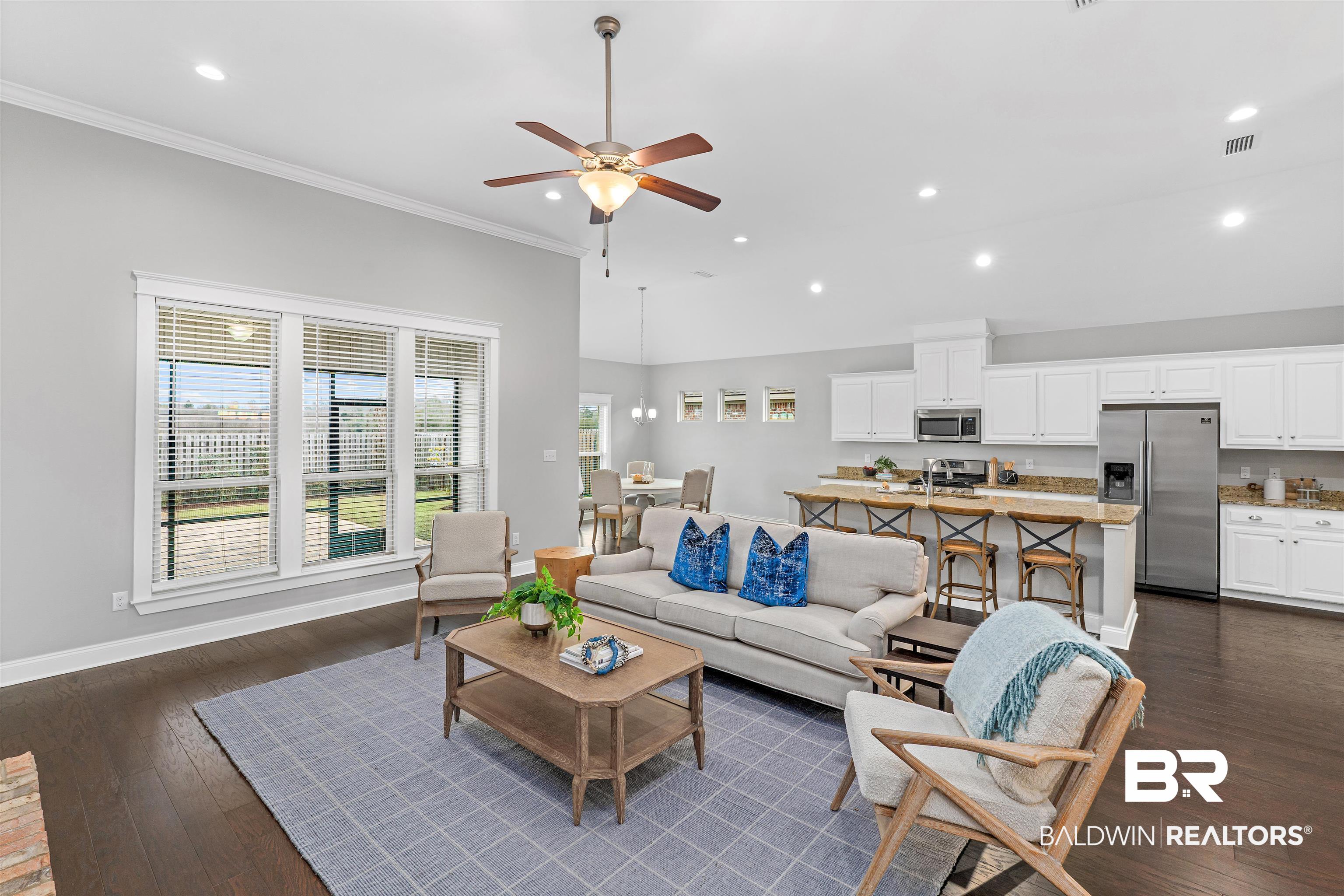 24838 Slater Mill Road Daphne, AL 36526 - Photo 5 of 46 Living area featuring dark wood-style floors, ceiling fan, recessed lighting, a high ceiling, and ornamental molding
