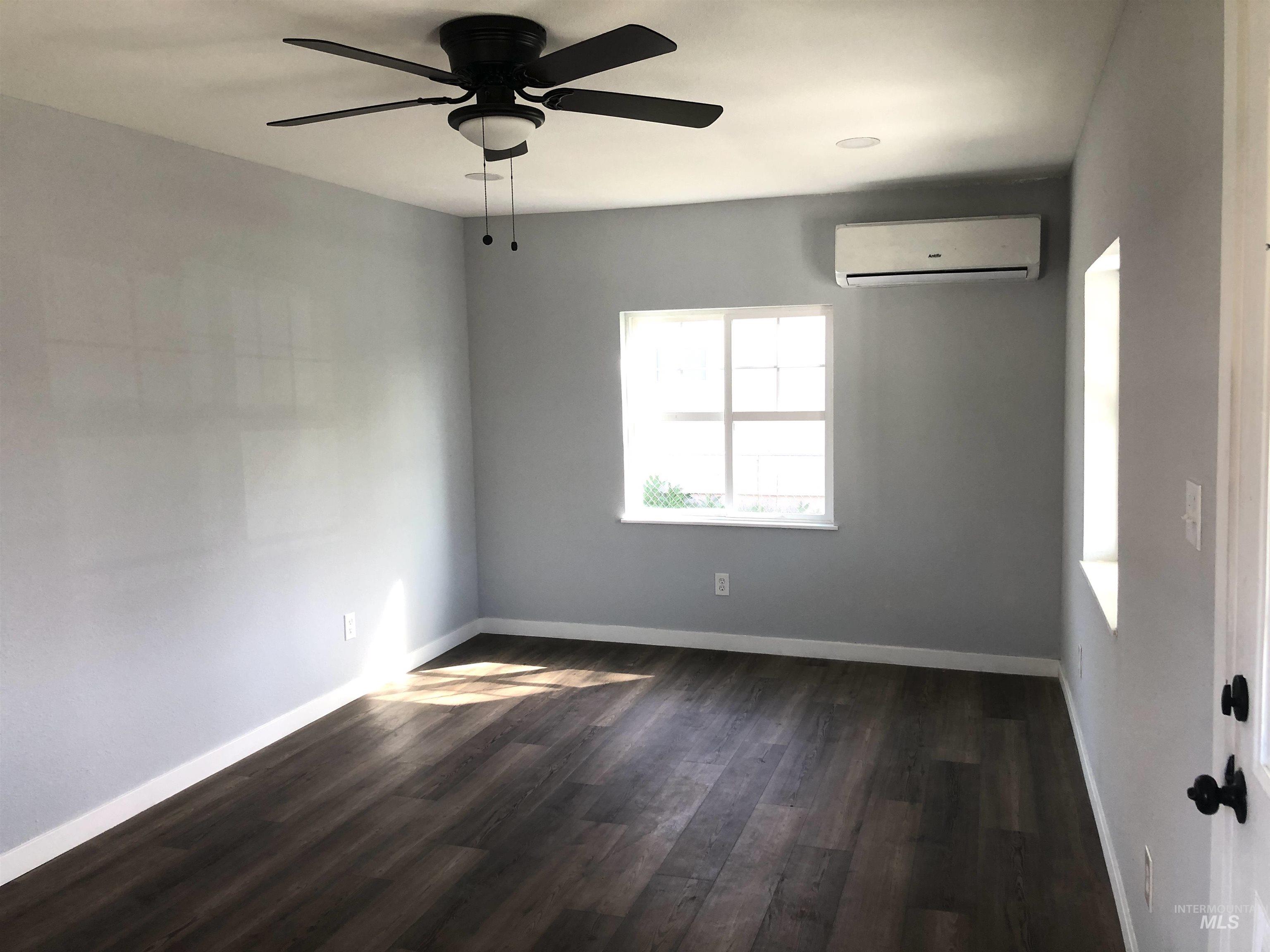 717 10th Street Clarkston, WA 99403 - Photo 11 of 23 Empty room with ceiling fan, dark wood-style floors, and a wall mounted mini split