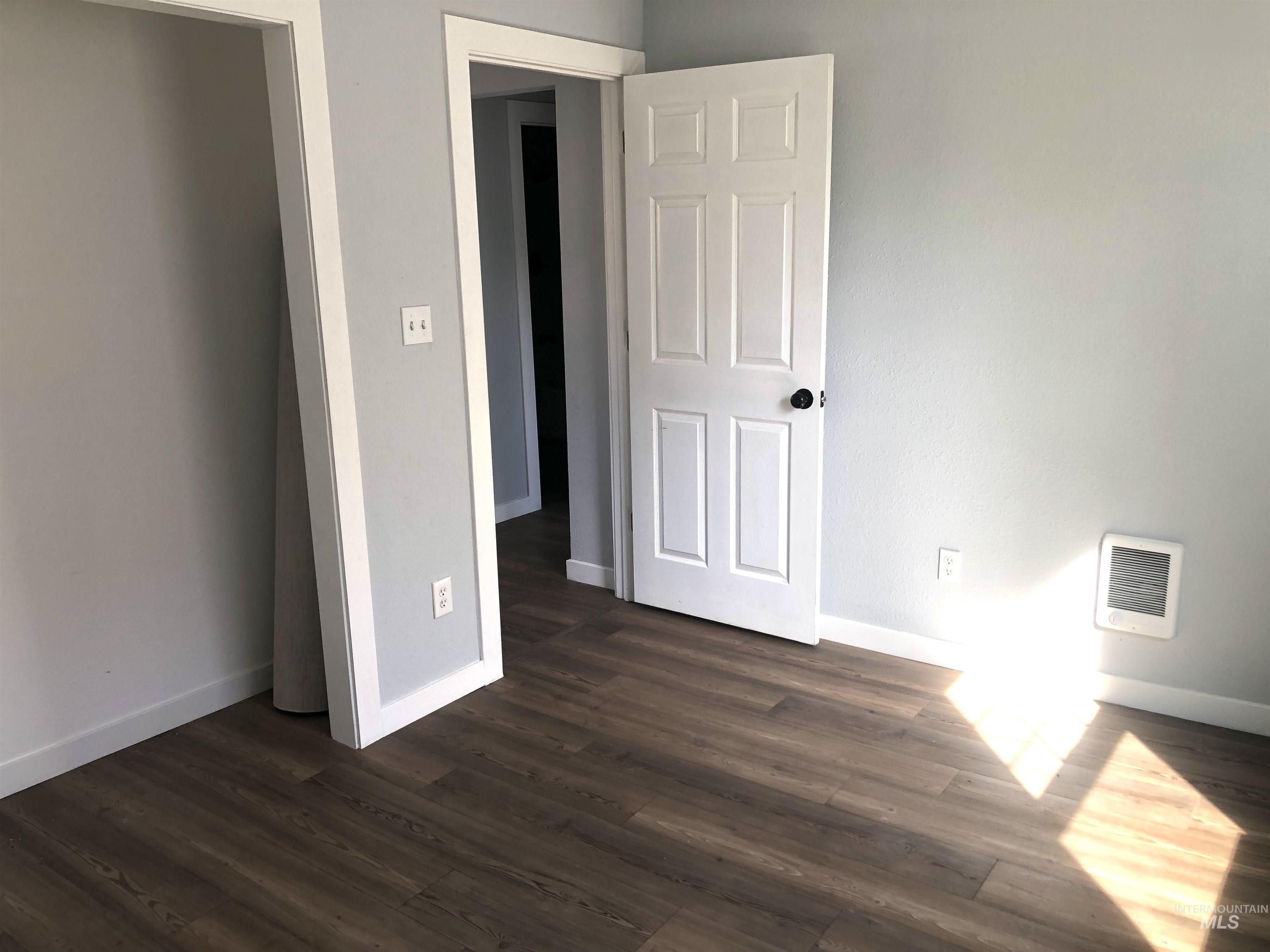 717 10th Street Clarkston, WA 99403 - Photo 13 of 23 Unfurnished bedroom featuring dark wood-type flooring and heating unit