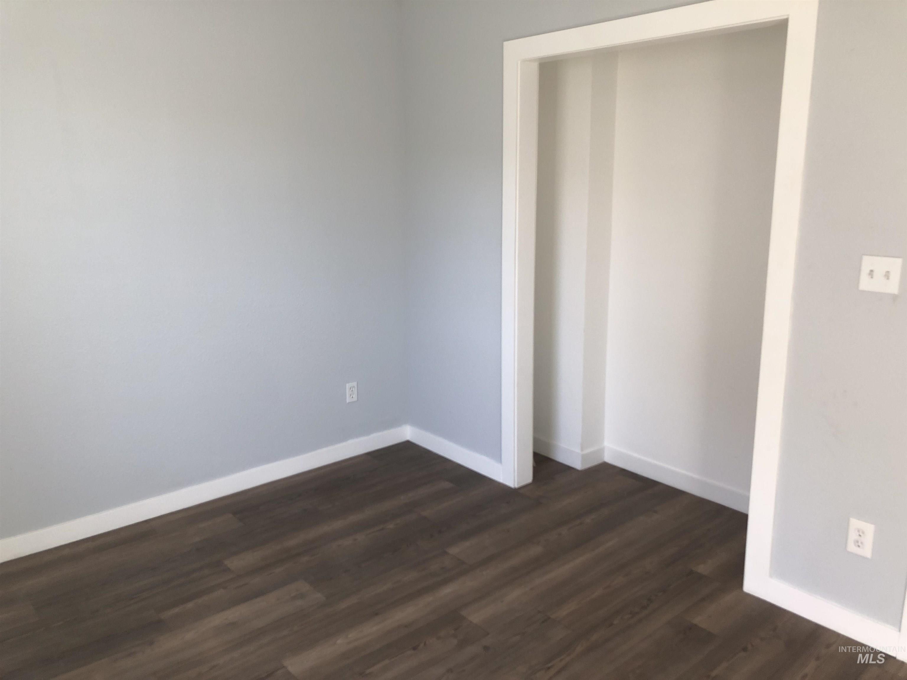 717 10th Street Clarkston, WA 99403 - Photo 14 of 23 Unfurnished bedroom with baseboards and dark wood-type flooring