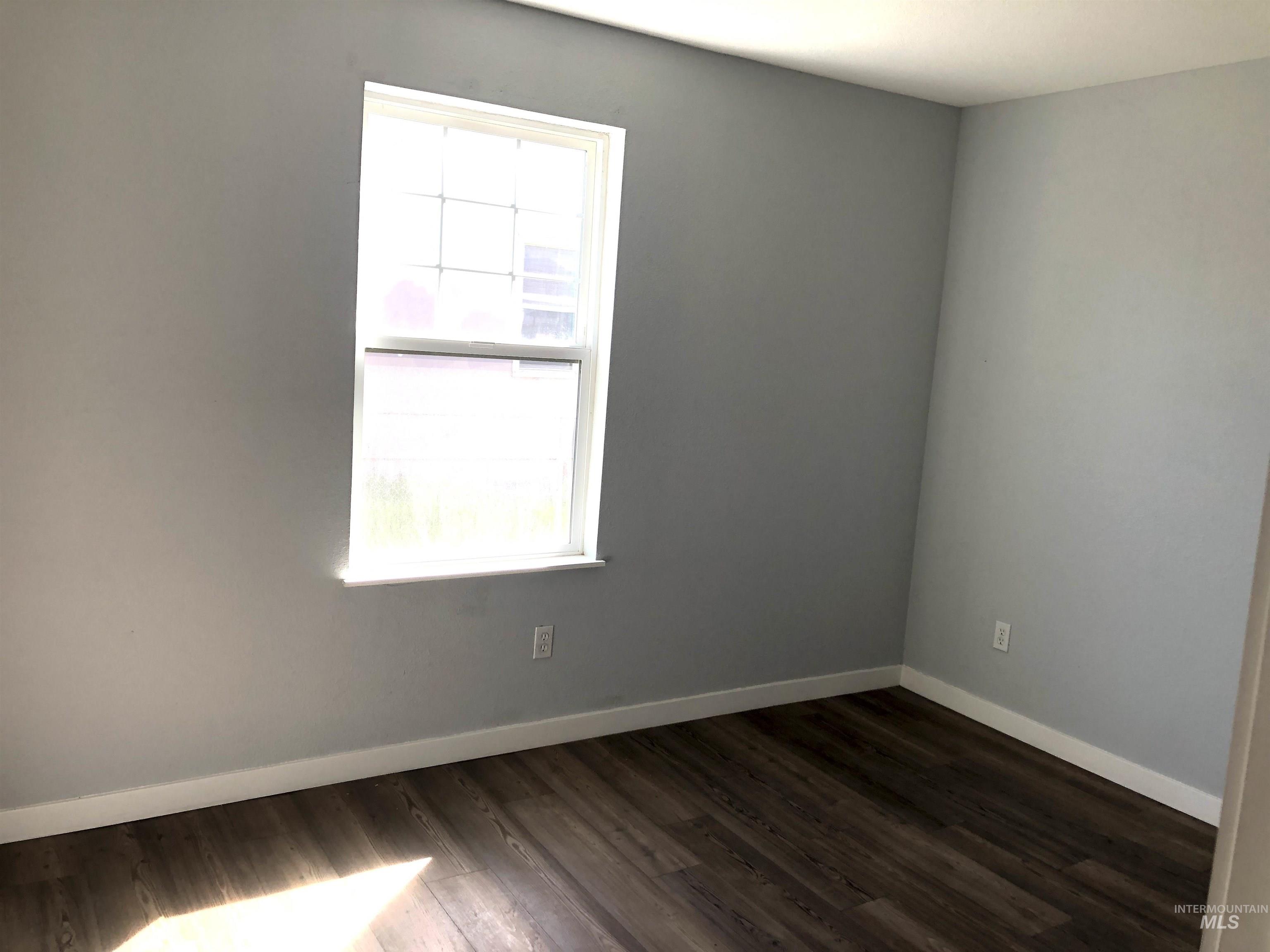717 10th Street Clarkston, WA 99403 - Photo 15 of 23 Spare room featuring dark wood-style floors and baseboards