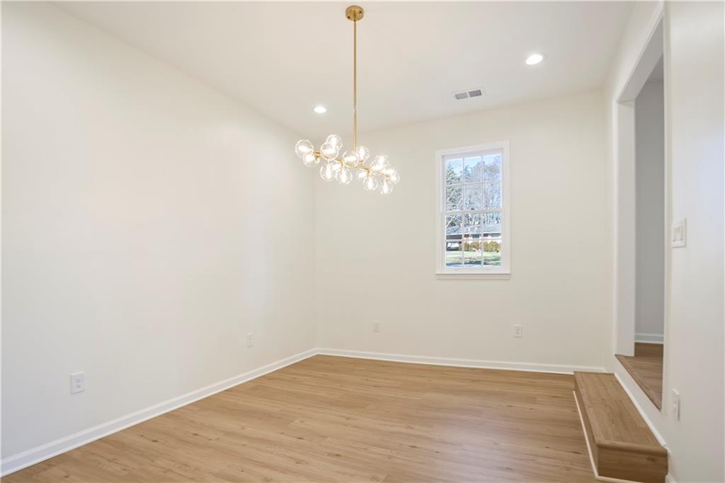 626 Reed Road Smyrna, GA 30082 - Photo 14 of 40 a view of a hallway with chandelier and wooden floor