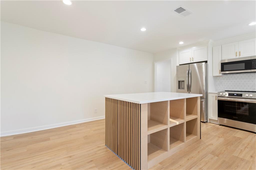 626 Reed Road Smyrna, GA 30082 - Photo 21 of 40 a view of kitchen with stainless steel appliances wooden floor and cabinets