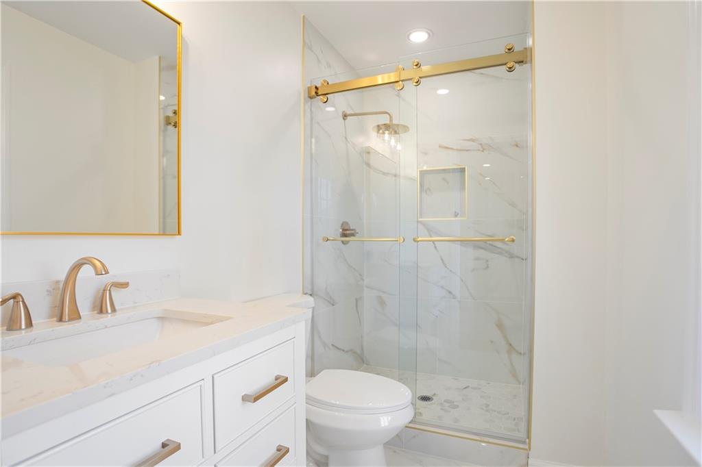 626 Reed Road Smyrna, GA 30082 - Photo 27 of 40 a bathroom with a shower sink vanity mirror and toilet