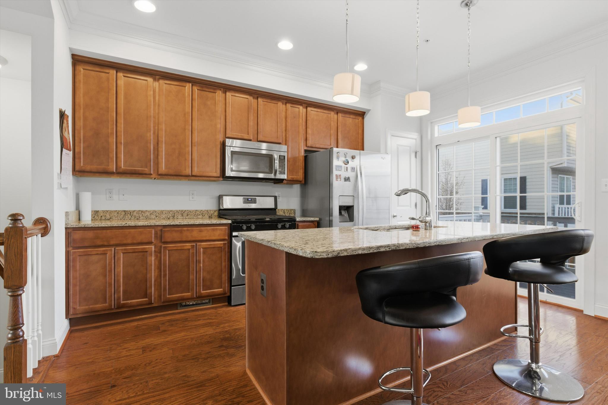 7206 Wood Meadow Way Lanham, MD 20706 - Photo 25 of 61 a kitchen with stainless steel appliances granite countertop a sink a stove a refrigerator cabinets and a dining table