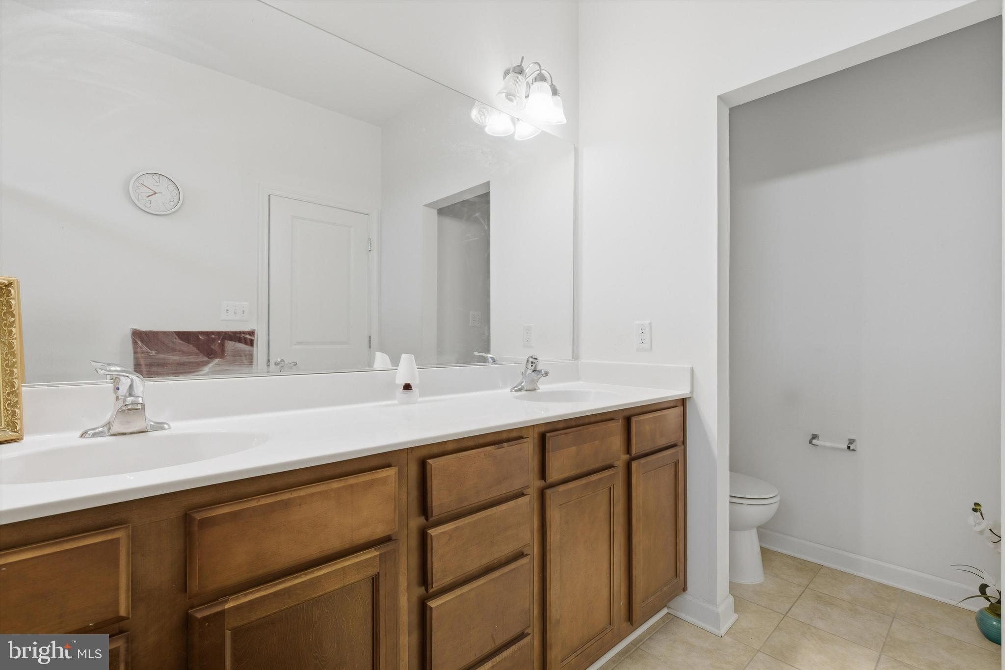 7206 Wood Meadow Way Lanham, MD 20706 - Photo 42 of 61 a bathroom with a double vanity sink toilet and a mirror