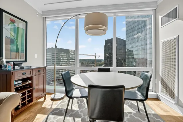 a dining room with furniture and a floor to ceiling window