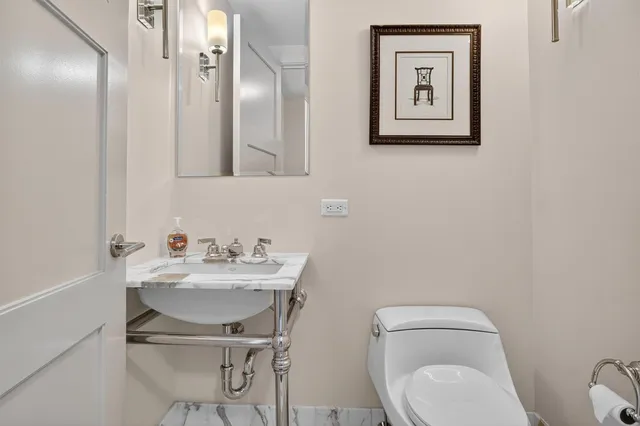 a bathroom with a toilet a sink and mirror