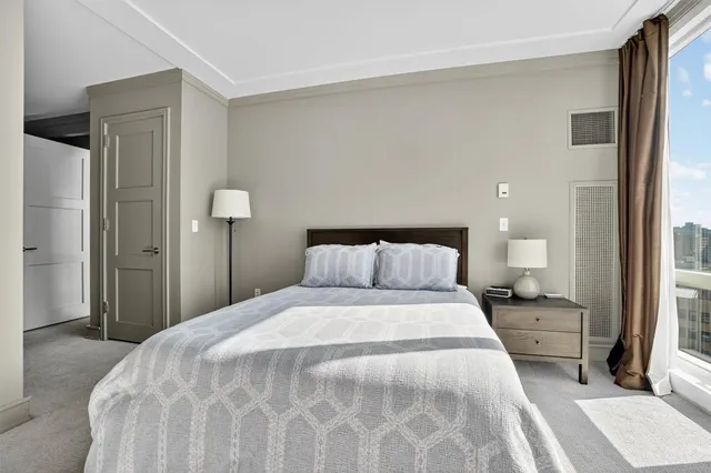 a bedroom with a bed and a large mirror