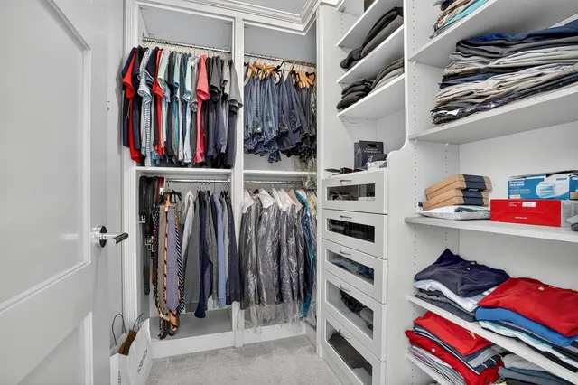 a view of walk in closet with clothes and shoes