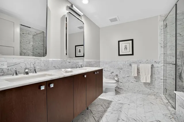 a bathroom with a double vanity sink mirror and toilet
