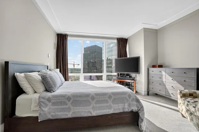 a bedroom with a bed and large windows