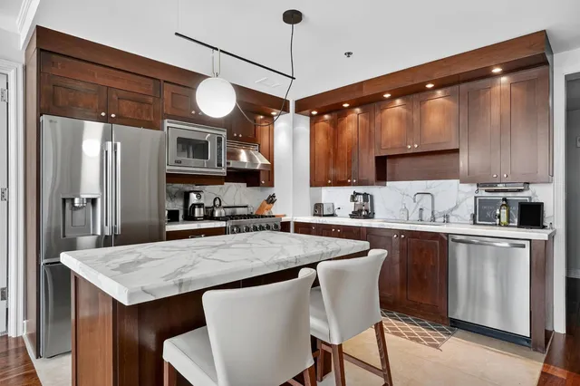 a kitchen with cabinets a center island and appliances